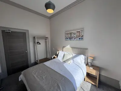 a bedroom with a bed with white sheets and pillows at The Comet - Macaulay Letting in Helensburgh