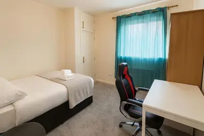 a hotel room with a bed and a desk and a table at Bright & Spacious 2 Bedroom Flat in Edinburgh
