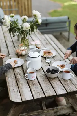 a wooden picnic table with plates of food and drinks at The Coach House in Castle Douglas