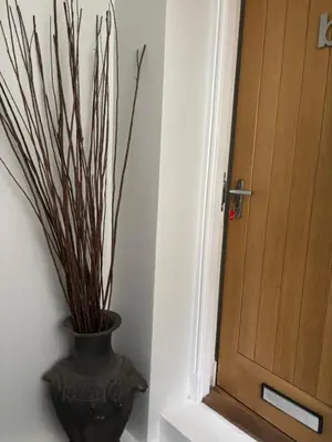 a vase with branches in it next to a door at Thistle Tide 13 Nelson Street Largs KA308LN 1st Floor in Largs