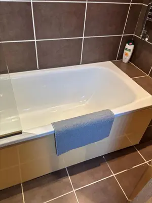 a bath tub with a blue towel on top of it at Thistle Tide 13 Nelson Street Largs KA308LN 1st Floor in Largs