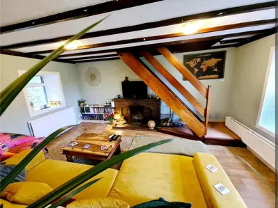 a living room with a yellow couch and a fireplace at Rock Cottage in Isle of Arran