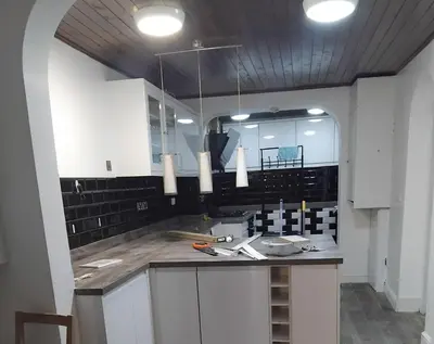 a kitchen with white cabinets and a counter top at 3 Bedroom house Abbey wood London in Moffat