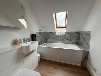 a white bathroom with a tub and a sink at Highland Nook for 4 in Fort William