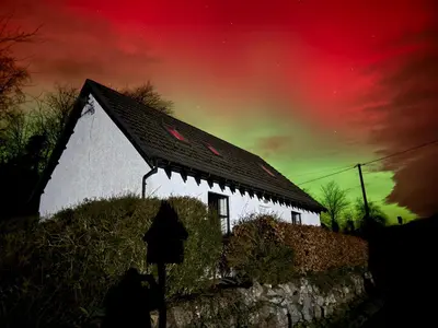 a white building with a roof under a colorful sky at Highland Nook for 4 in Fort William
