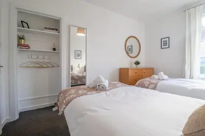 a bedroom with two beds and a mirror at Ashgrove House - 3 bedroom in Coatbridge
