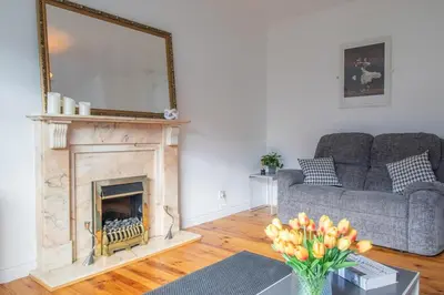 a living room with a couch and a fireplace at Ashgrove House - 3 bedroom in Coatbridge