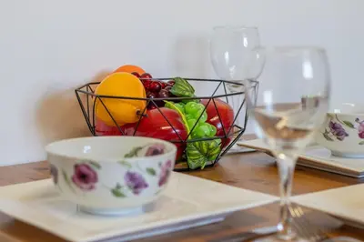 a basket of fruit on a table next to a wine glass at Ashgrove House - 3 bedroom in Coatbridge