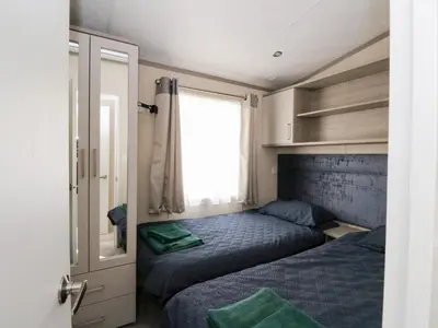 a small bedroom with two beds and a window at Altair Lodge in Crieff