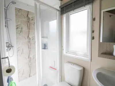 a bathroom with a shower and a toilet and a sink at Altair Lodge in Crieff