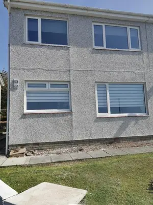 a gray building with three windows and a yard at Seafield Crt, North Shore Beach in Horse Isle