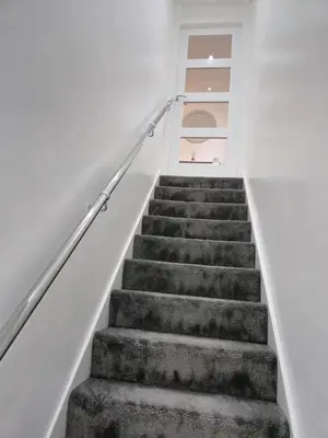 a staircase in a house with white walls and concrete stairs at Seafield Crt, North Shore Beach in Horse Isle