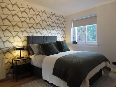 a bedroom with a large bed and a window at Malina at The Green in Glasgow