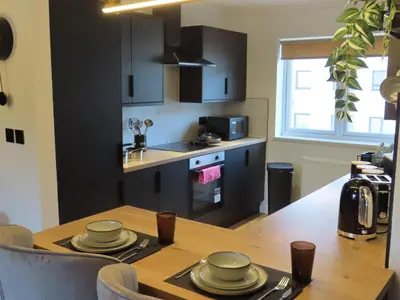 a kitchen and dining room with a wooden table at Malina at The Green in Glasgow