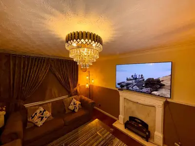 a living room with a couch and a flat screen tv at Likewise Modern Two bedrooms Home for 4 in Glasgow Area in Pollokshaws
