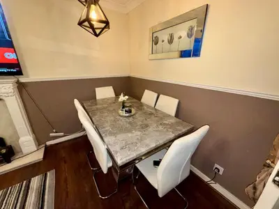 a dining room with a table and white chairs at Likewise Modern Two bedrooms Home for 4 in Glasgow Area in Pollokshaws