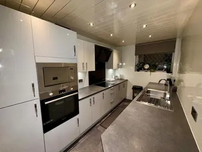 a kitchen with white cabinets and a stove top oven at Likewise Modern Two bedrooms Home for 4 in Glasgow Area in Pollokshaws