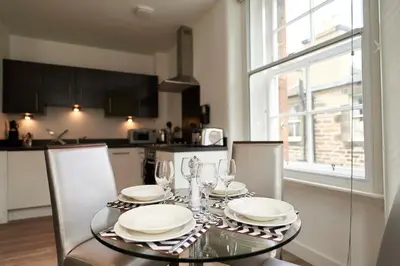 a dining room table with plates and wine glasses at Braid Apartments by Mansley in Edinburgh