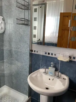 a bathroom with a sink and a mirror at The Old Smiddy Cottage and Apartment in Balloch