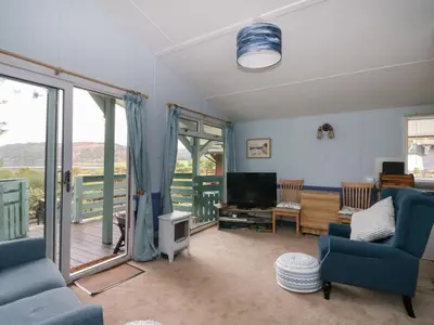 a living room with blue chairs and a television at Scarba in Oban