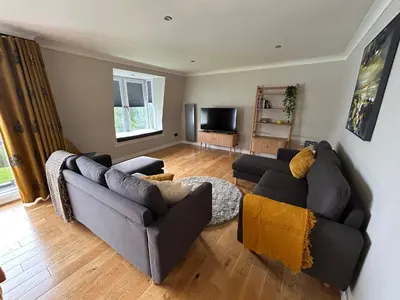 a living room with two couches and a television at Park View apartment, Gleneagles Village, Auchterarder in Auchterarder