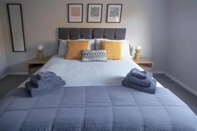 a bedroom with a bed with blue towels on it at Park View apartment, Gleneagles Village, Auchterarder in Auchterarder