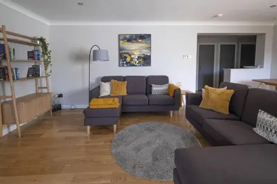a living room with a couch and a table at Park View apartment, Gleneagles Village, Auchterarder in Auchterarder
