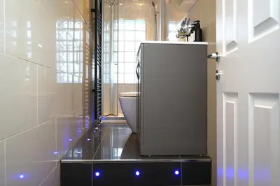 a bathroom with a toilet and a white refrigerator at Modern 3-Bed Flat Prime Falkirk Location in Falkirk