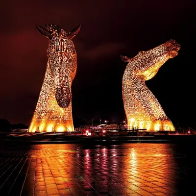 two statues of horses are lit up at night at Modern 3-Bed Flat Prime Falkirk Location in Falkirk