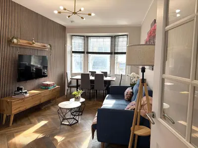 a living room with a blue couch and a table at Modern 3-Bed Flat Prime Falkirk Location in Falkirk