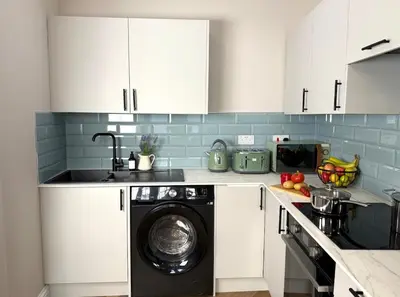 a kitchen with a washing machine in a kitchen at Modern 3-Bed Flat Prime Falkirk Location in Falkirk