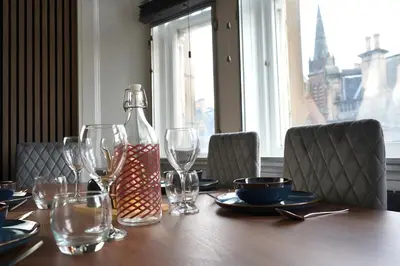a table with wine glasses and a bottle on it at Modern 3-Bed Flat Prime Falkirk Location in Falkirk