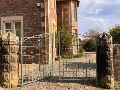 an entrance to a brick building with an iron gate at Dungora House in Crieff