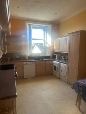 a kitchen with a sink and a washing machine at Crawford House in Largs