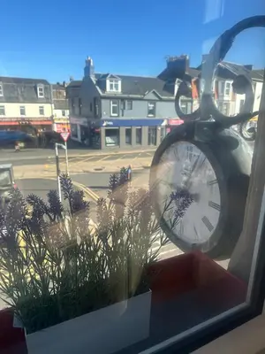 a window with a clock and some plants at Crawford House in Largs