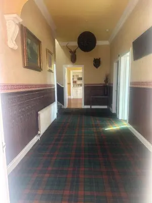 an empty hallway with a rug on the floor at Crawford House in Largs