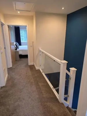 a hallway with a stairway with a blue wall at Balnakeil house