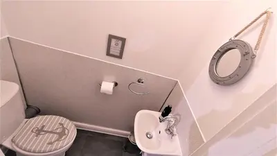 a bathroom with a toilet and a sink and a mirror at Ashdale Cottage with Sauna, Plunge Pool, Games Room, Kit Drying Room in Isle of Arran