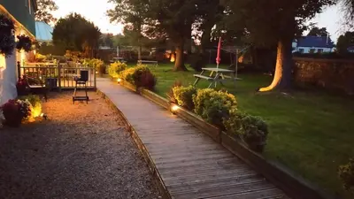 a wooden walkway in a yard with a park at Ashdale Cottage with Sauna, Plunge Pool, Games Room, Kit Drying Room in Isle of Arran