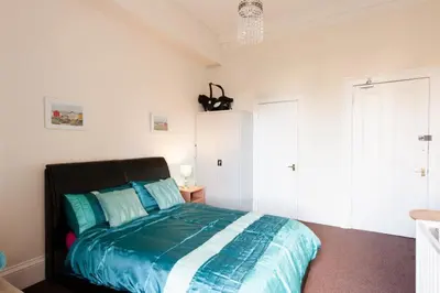 a bedroom with a bed with blue and white sheets at Edinburgh Central Lauriston Large Apartment in Edinburgh