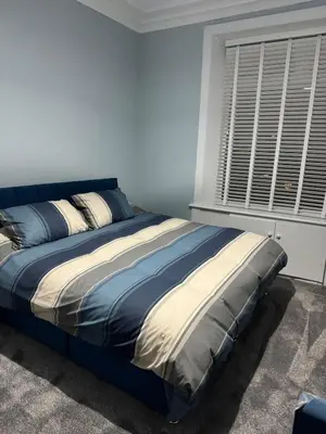 a large bed in a bedroom with a window at Woodside Bungalow in Stevenston