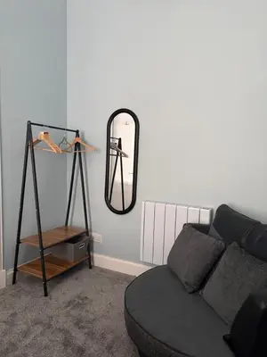 a living room with a couch and a mirror at Woodside Bungalow in Stevenston