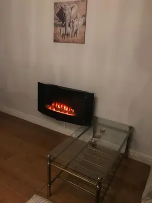 a fireplace in the corner of a room with a glass table at 2 new bold lawns leamington spa in Moffat