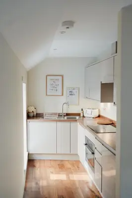 a kitchen with white cabinets and a sink at Charming Central Mews Home with Secure Parking in Edinburgh