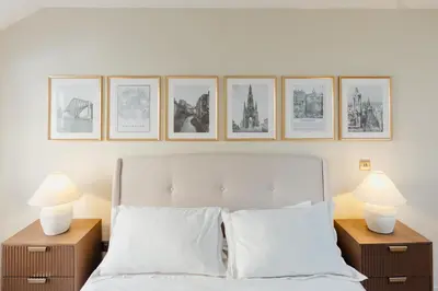 a bedroom with a bed with four pictures on the wall at Charming Central Mews Home with Secure Parking in Edinburgh