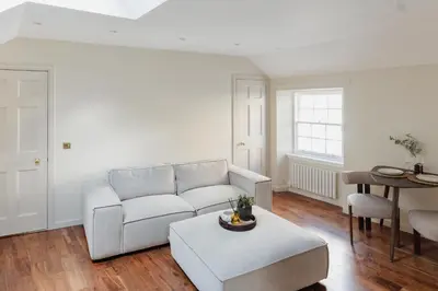 a living room with a couch and a table at Charming Central Mews Home with Secure Parking in Edinburgh