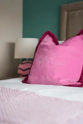 a pink pillow sitting on top of a bed at Beechgrove House in Livingston