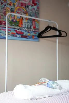 a bottle on top of a bed with a hanger at Beechgrove House in Livingston