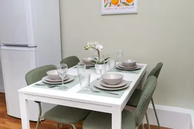 a white dining room table with chairs and plates and glasses at 2Bed Upper Cottage-Street Parking-by Holiday Homes in Falkirk