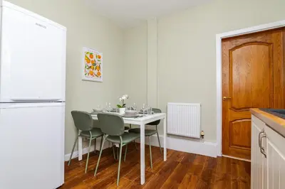 a kitchen with a table and chairs in a room at 2Bed Upper Cottage-Street Parking-by Holiday Homes in Falkirk